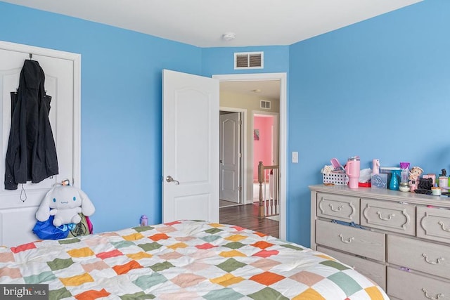 bedroom with visible vents and wood finished floors