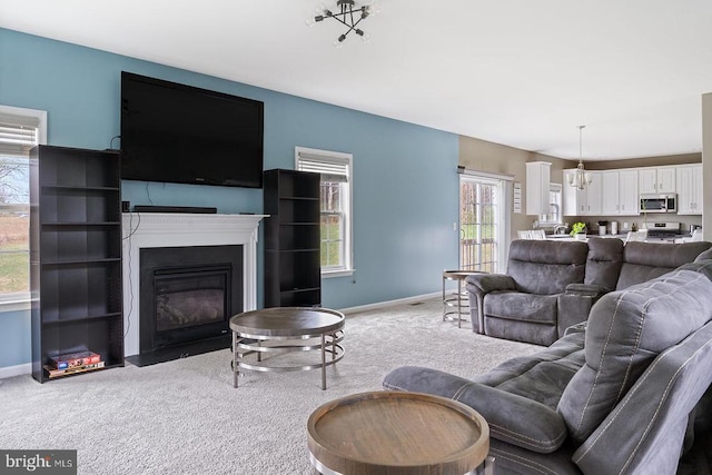 living area featuring light carpet, a wealth of natural light, and baseboards