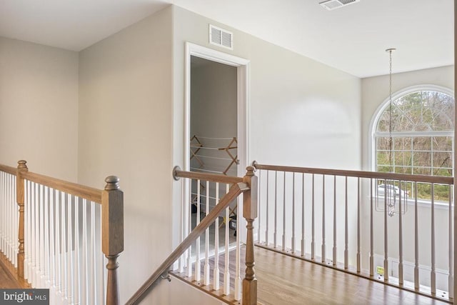hallway with visible vents and an upstairs landing