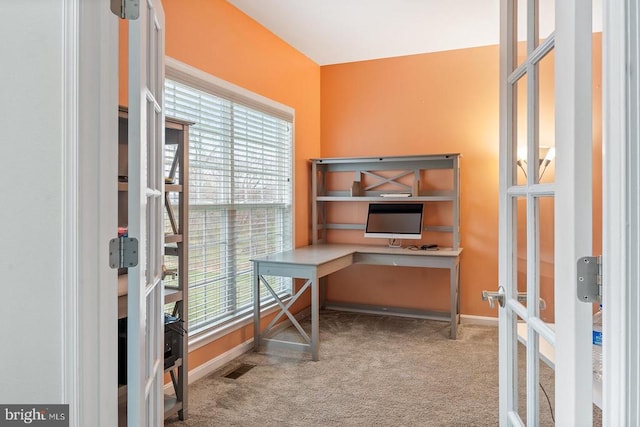 unfurnished office with baseboards, carpet flooring, and plenty of natural light