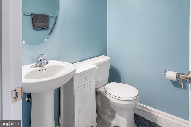 bathroom featuring toilet, baseboards, and tile patterned floors