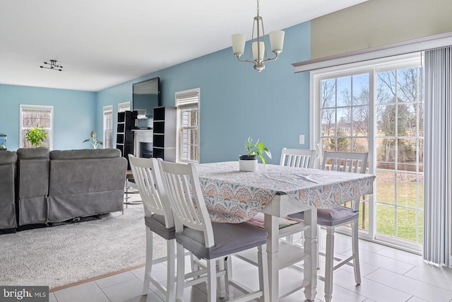 tiled dining room featuring an inviting chandelier