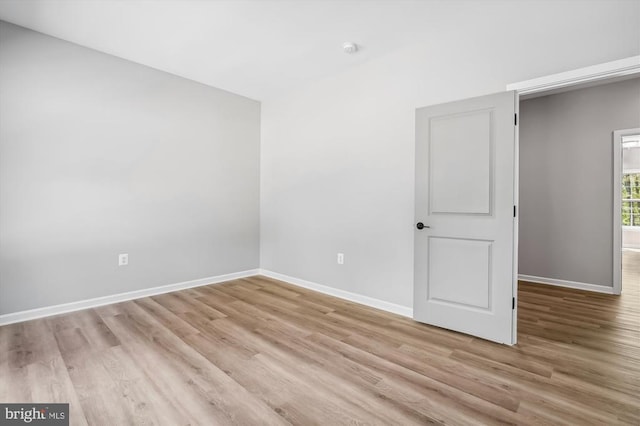  - empty room with light wood finished floors and baseboards