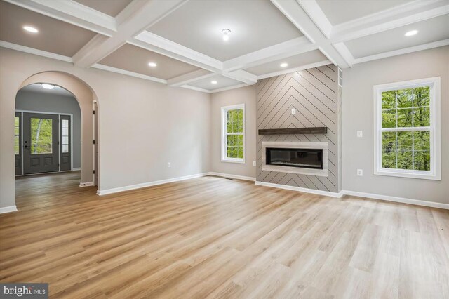  - unfurnished living room with coffered ceiling, arched walkways, baseboards, light wood-style flooring, and beamed ceiling
