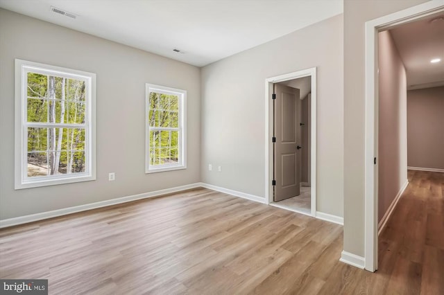  - empty room with light wood finished floors and baseboards