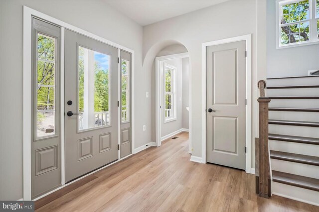  - foyer featuring light wood-style floors, stairway, and baseboards