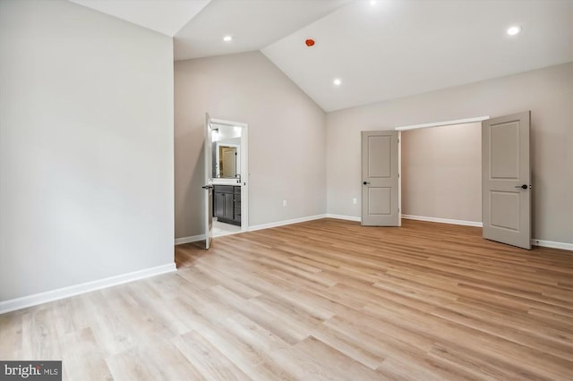  - unfurnished bedroom with light wood-style floors, high vaulted ceiling, baseboards, ensuite bathroom, and recessed lighting