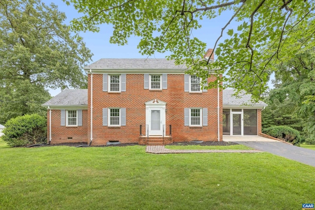 7928 Howardsville Rd, Scottsville, VA 24562 - colonial-style house featuring a front yard, brick siding, a sunroom, and a shingled roof