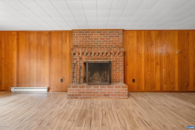 7928 Howardsville Rd, Scottsville, VA 24562 - unfurnished living room with baseboard heating, wood finished floors, a brick fireplace, and wooden walls
