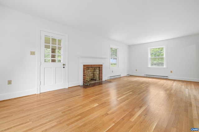 7928 Howardsville Rd, Scottsville, VA 24562 - unfurnished living room with light wood-style flooring, a baseboard radiator, and a fireplace