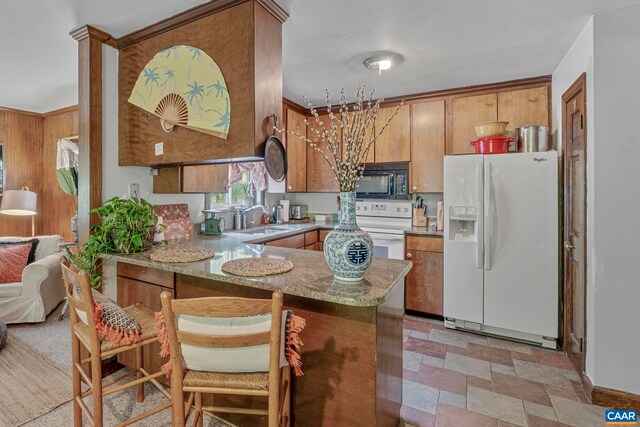 1842 Ed Jones Rd, Scottsville, VA 24590 - kitchen featuring white appliances, a sink, a peninsula, light stone finish flooring, and brown cabinetry