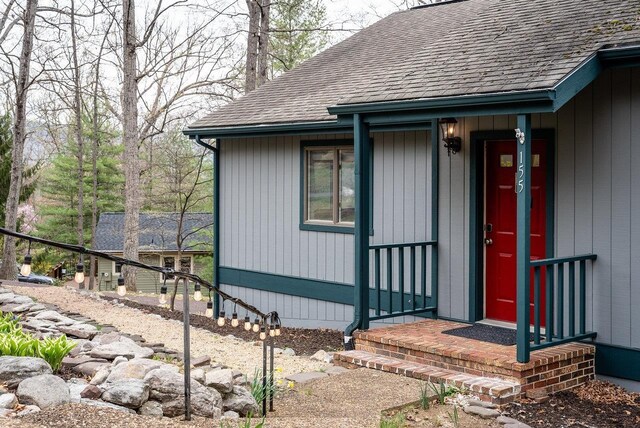entrance to property featuring a shingled roof