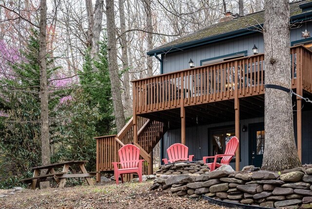 back of house with a chimney, stairs, a patio area, a deck, and roof with shingles