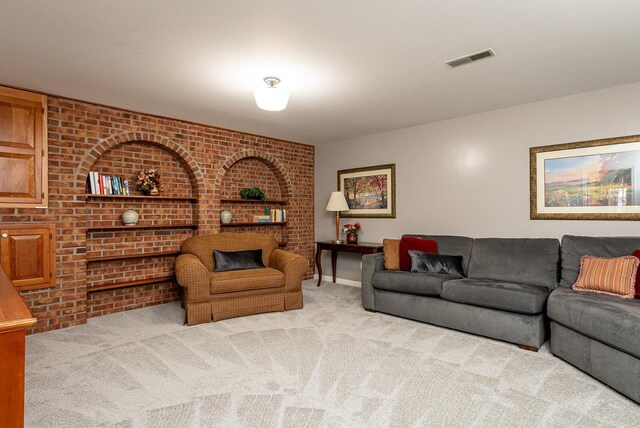living room with carpet flooring, brick wall, and baseboards
