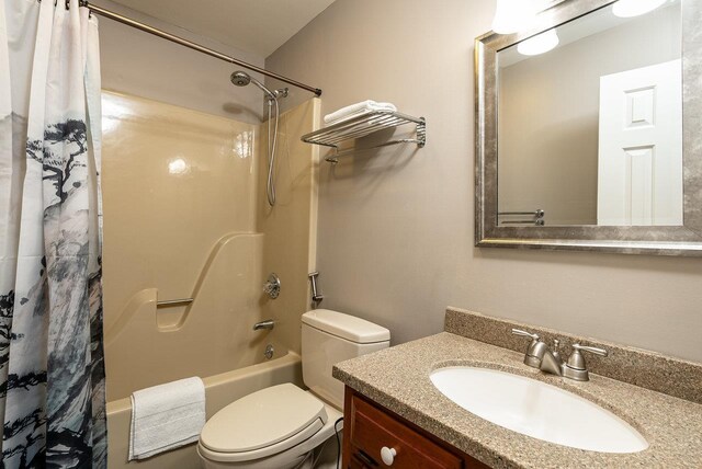 full bathroom featuring shower / tub combo with curtain, toilet, and vanity