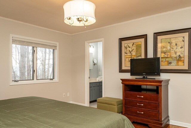 bedroom with ornamental molding and ensuite bathroom