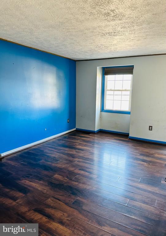 empty room with wood finished floors, baseboards, and a textured ceiling