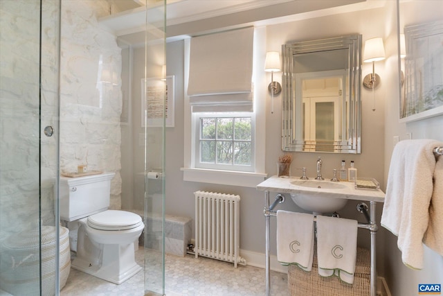 bathroom featuring toilet, a stall shower, a sink, and radiator heating unit