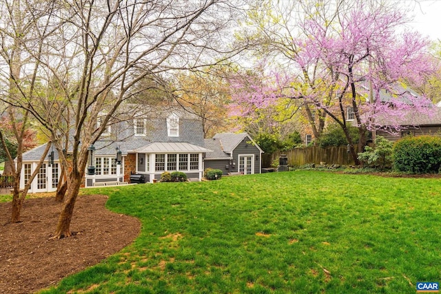 back of house featuring a yard, fence, and french doors