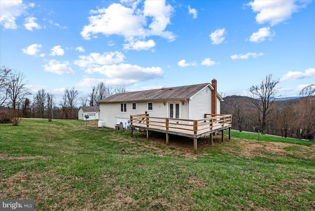 back of house featuring a wooden deck, french doors, a lawn, and a chimney