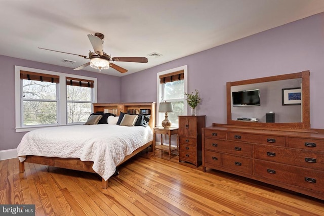 bedroom with multiple windows, light wood-style flooring, and ceiling fan