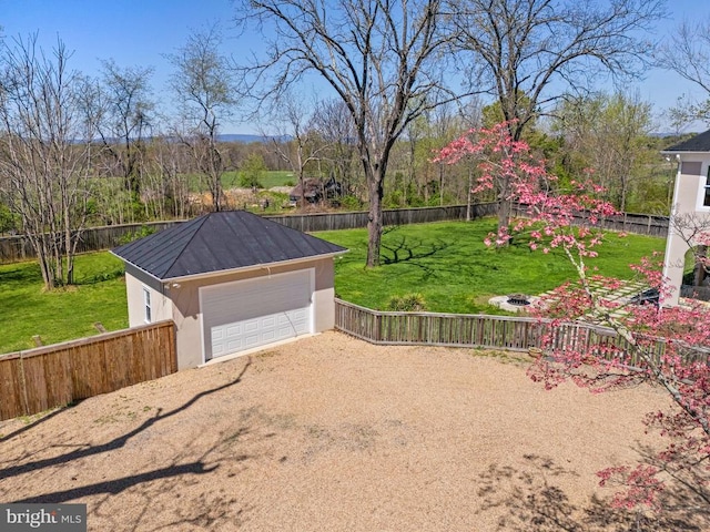 view of yard with dirt driveway and a detached garage