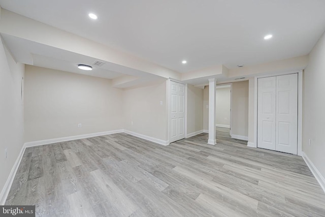 finished below grade area featuring baseboards, visible vents, light wood-style flooring, and recessed lighting