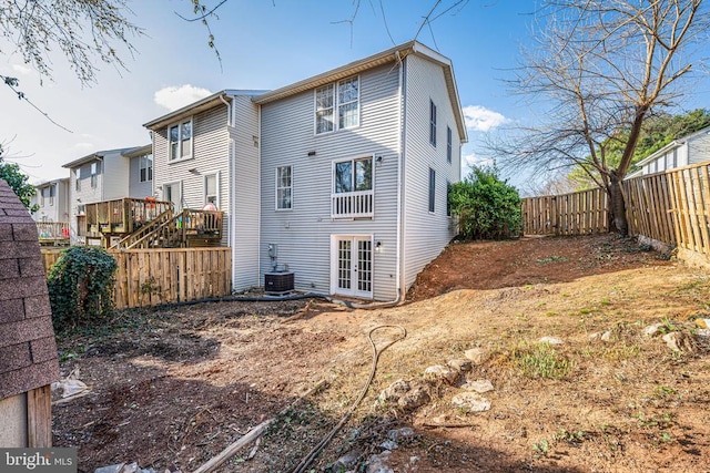 rear view of house with french doors and a fenced backyard