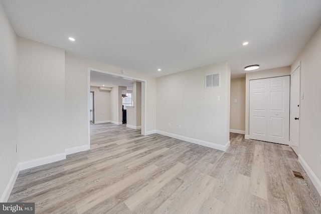 empty room featuring light wood-type flooring, baseboards, and visible vents