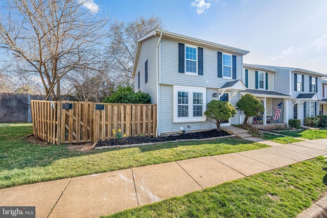 view of front of home with a front lawn, a porch, and fence