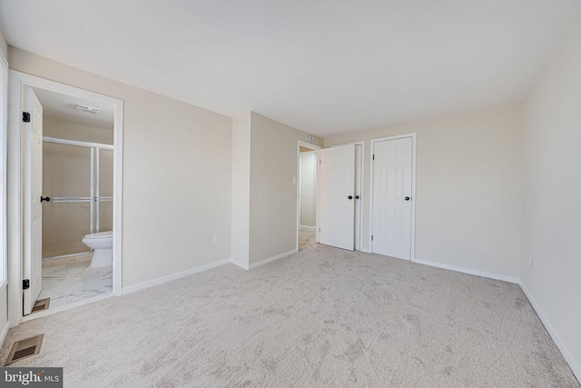 unfurnished bedroom with baseboards, connected bathroom, visible vents, and carpet floors