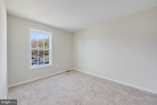 carpeted spare room with baseboards and visible vents