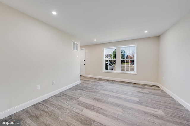spare room with baseboards, recessed lighting, visible vents, and wood finished floors