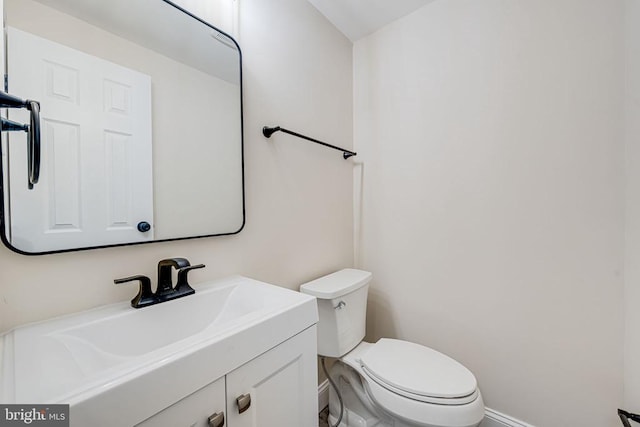 bathroom with vanity, toilet, and baseboards