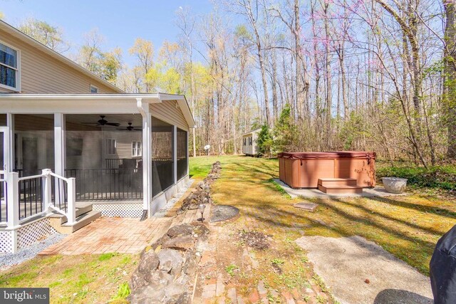 11523 Red Rock Ln, Bumpass, VA 23024 - view of green lawn featuring a hot tub, a sunroom, a ceiling fan, and a patio area