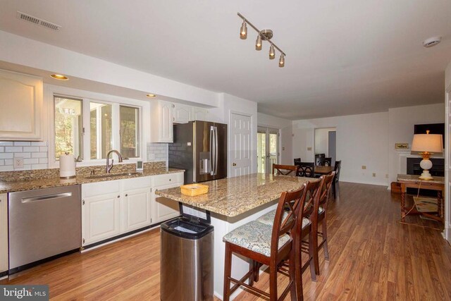 11523 Red Rock Ln, Bumpass, VA 23024 - kitchen with appliances with stainless steel finishes, light wood-type flooring, a breakfast bar area, and backsplash