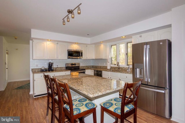 11523 Red Rock Ln, Bumpass, VA 23024 - kitchen featuring stainless steel appliances, a kitchen breakfast bar, white cabinetry, and light stone counters