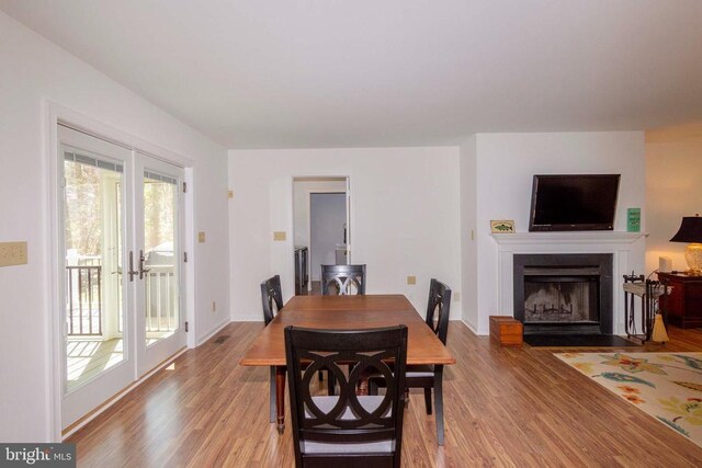 11523 Red Rock Ln, Bumpass, VA 23024 - dining space with light wood-type flooring and a fireplace with flush hearth