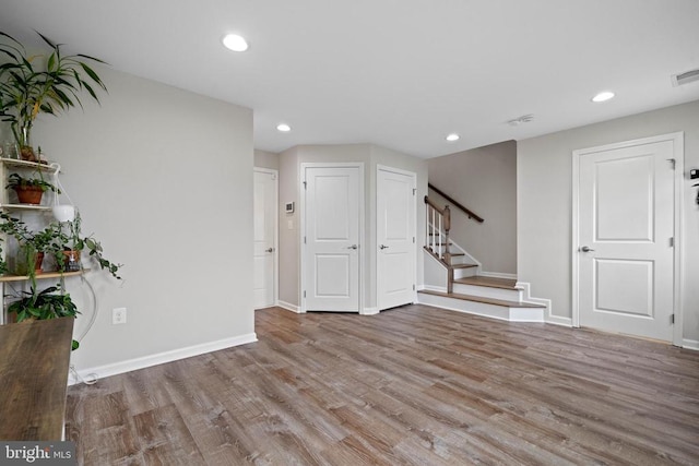  - empty room with stairway, wood finished floors, baseboards, and recessed lighting