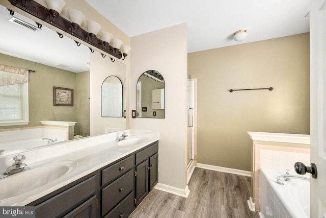 13104 Willow Point Dr, Fredericksburg, VA 22408 - bathroom with wood finished floors, a bath, double vanity, baseboards, and a shower with shower door