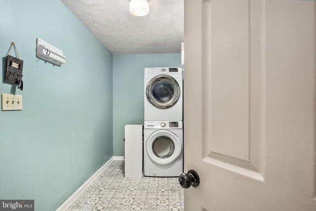 13104 Willow Point Dr, Fredericksburg, VA 22408 - laundry area featuring stacked washer / drying machine, a textured ceiling, tile patterned floors, and baseboards