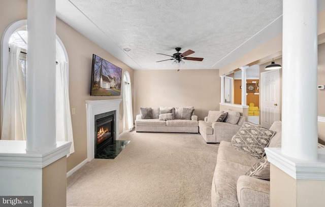 13104 Willow Point Dr, Fredericksburg, VA 22408 - living area featuring a textured ceiling, ceiling fan, a fireplace with flush hearth, carpet, and ornate columns