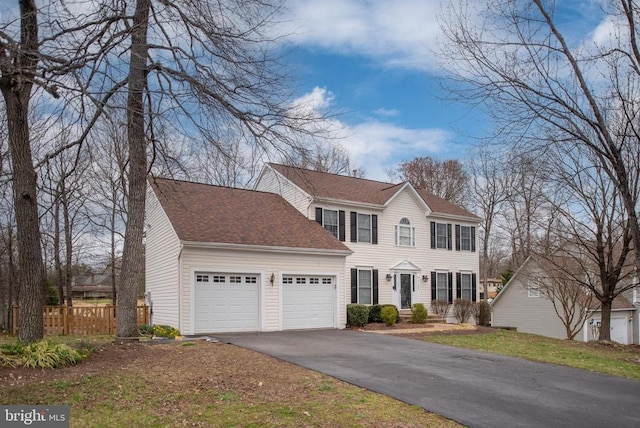 13104 Willow Point Dr, Fredericksburg, VA 22408 - colonial-style house featuring an attached garage, asphalt driveway, fence, and a shingled roof