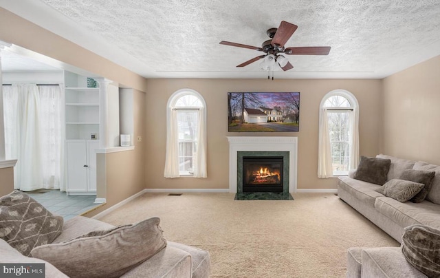 13104 Willow Point Dr, Fredericksburg, VA 22408 - carpeted living room with a textured ceiling, a fireplace with flush hearth, baseboards, and a ceiling fan