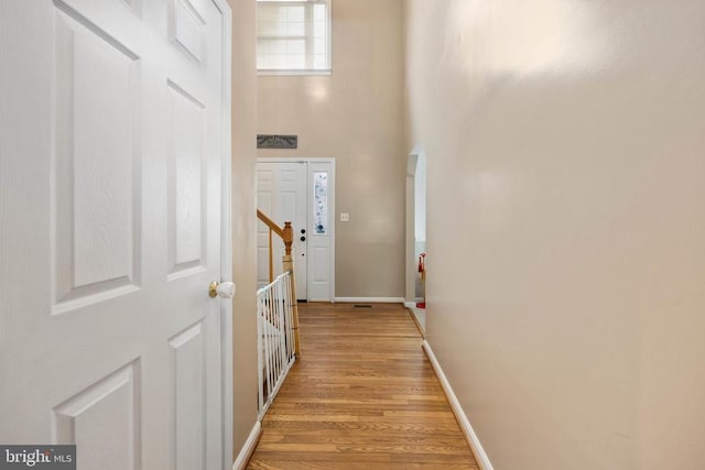 13104 Willow Point Dr, Fredericksburg, VA 22408 - hallway with light wood-type flooring, a towering ceiling, and baseboards