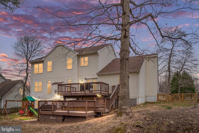 13104 Willow Point Dr, Fredericksburg, VA 22408 - back of house at dusk with a deck, fence, a playground, and a shingled roof