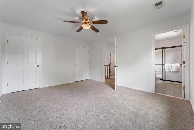 unfurnished bedroom featuring carpet floors, baseboards, and ensuite bathroom