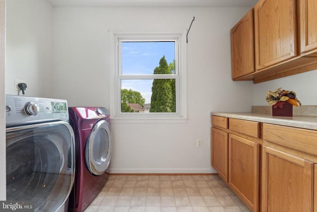 laundry room with separate washer and dryer, cabinet space, and baseboards