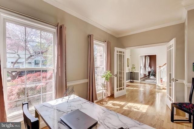 dining space featuring french doors, light wood-type flooring, and ornamental molding