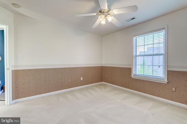 unfurnished room featuring healthy amount of natural light, carpet flooring, baseboards, and a ceiling fan